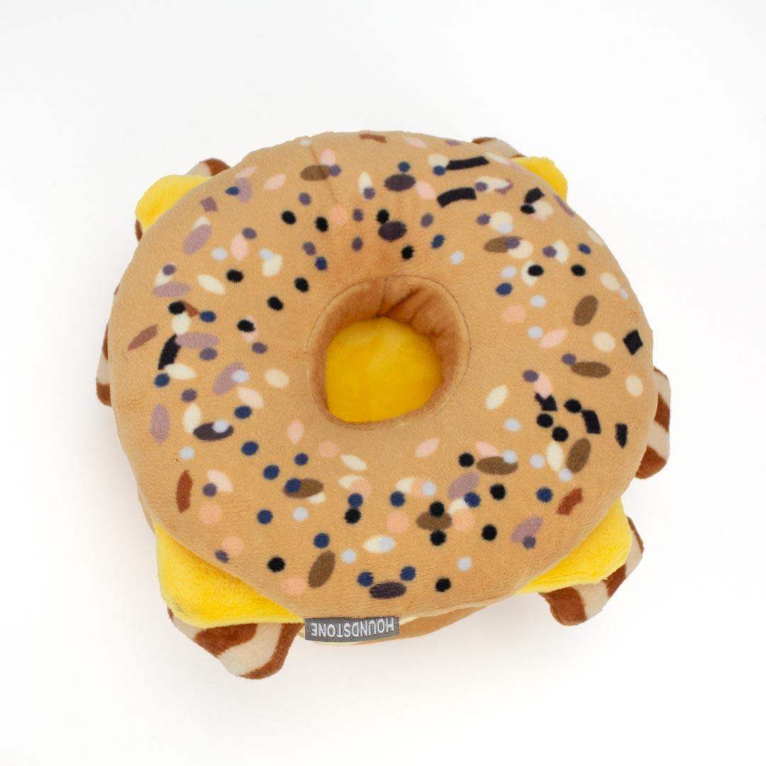 Plush bagel interactive dog toy with sesame seeds on a white background