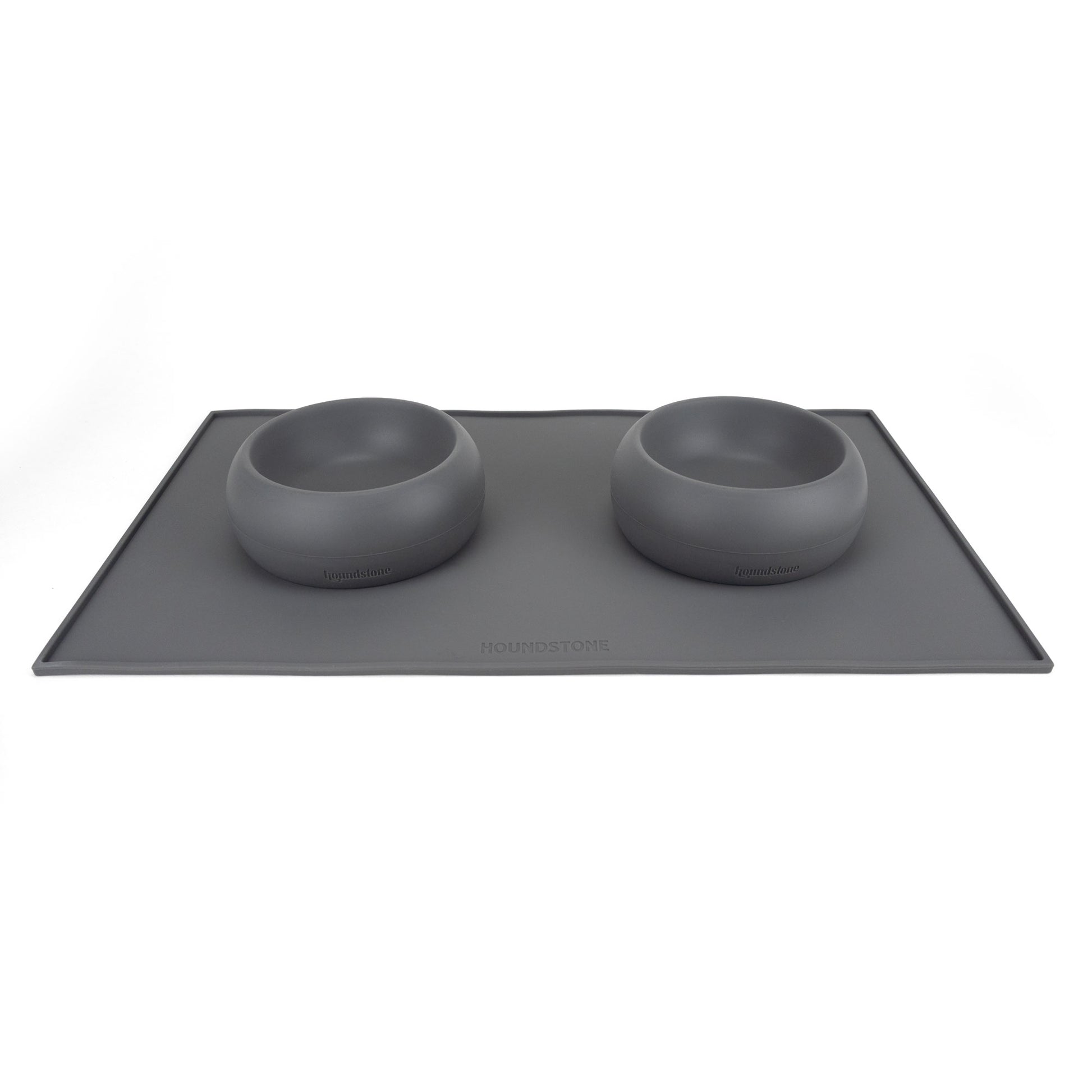 two small silicone dog food bowls on top of a houndstone dog bowl mat charcoal