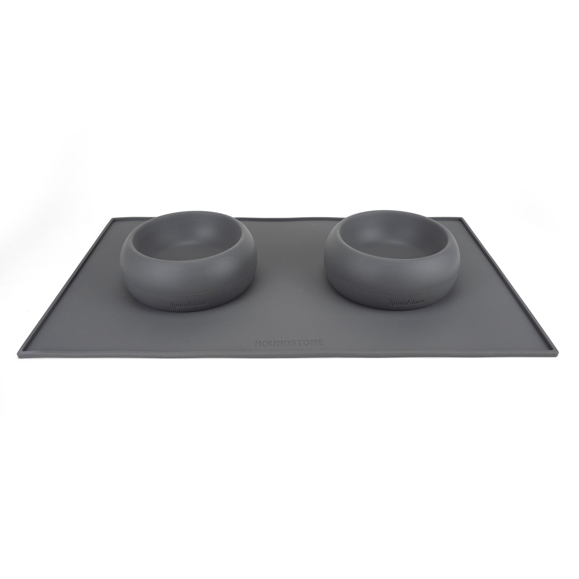 two small silicone dog food bowls on top of a houndstone dog bowl mat charcoal